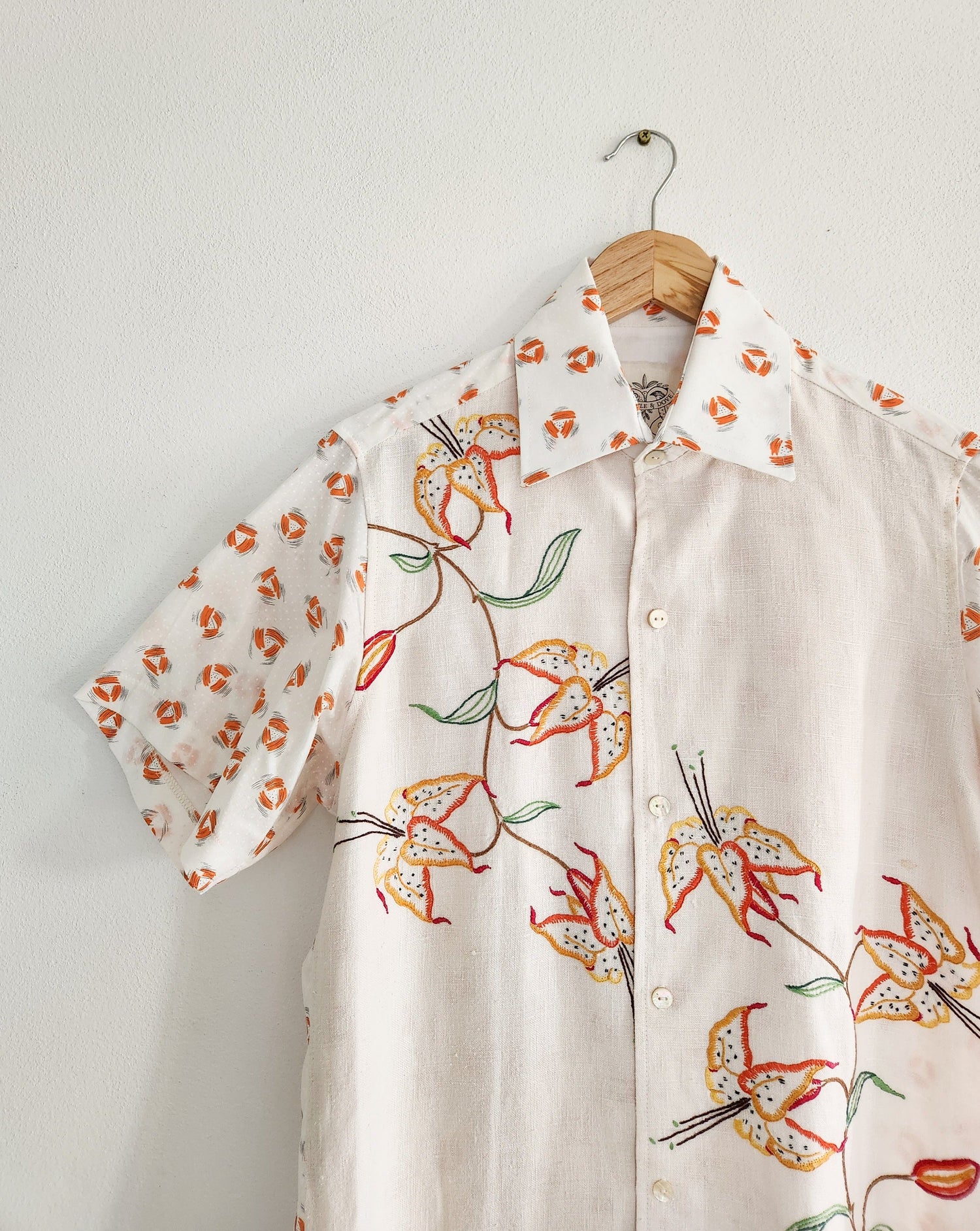 Man in floral shirt made from up-cycled fabrics. Red and green flowers with white background